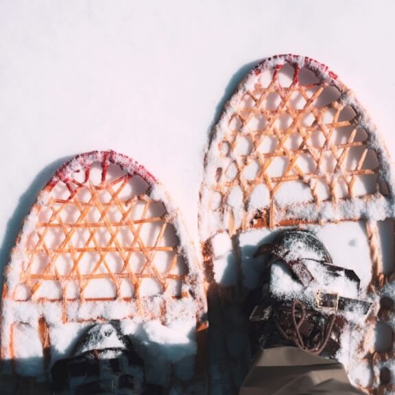 A photo of someone looking at their snowshoes.